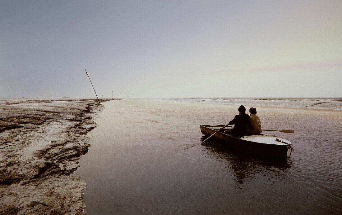 Zwei Männer im Ruderboot in einem Priel, Ostfriesisches Wattenmeer, Ostfriesland, Nordsee, Niedersachsen, Deutschland, Europa