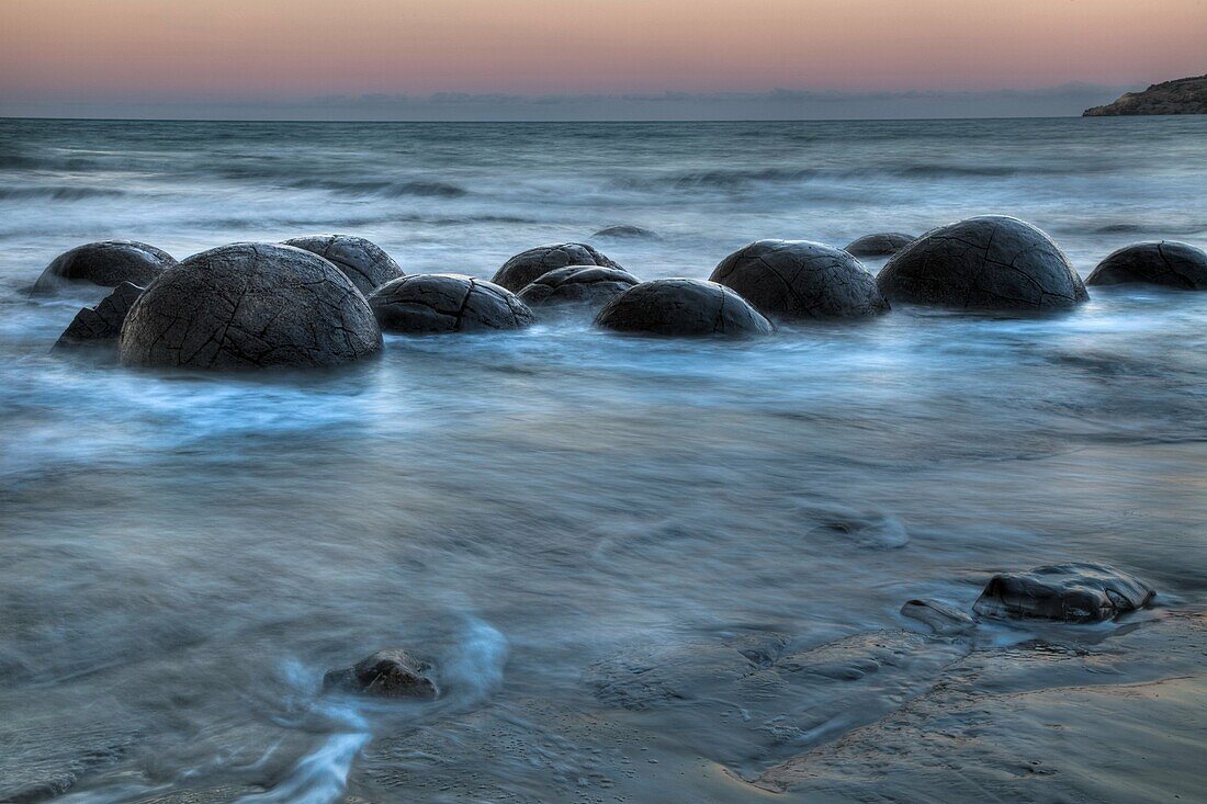 Moeraki boulders at dusk, glow over Pacific Ocean, near Oamaru, Otago, New Zealand