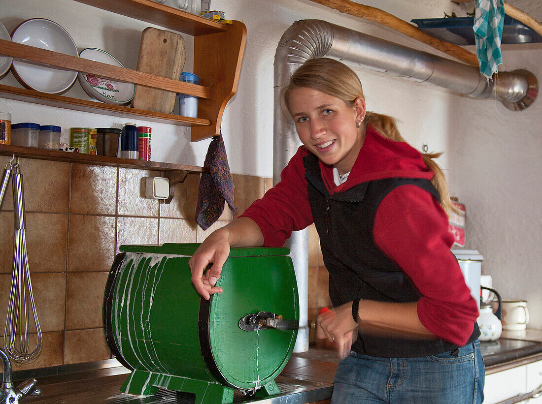 Woman with butter churn, Hofbauern-Alm, Kampenwand, Chiemgau, Upper Bavaria, Germany