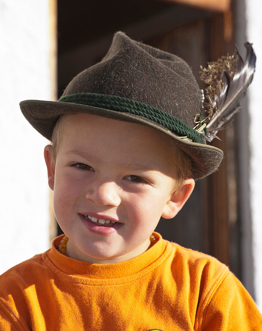 Boy (8-9 years) smiling at camera, Hofbauern-Alm, Kampenwand, Chiemgau, Upper Bavaria, Germany