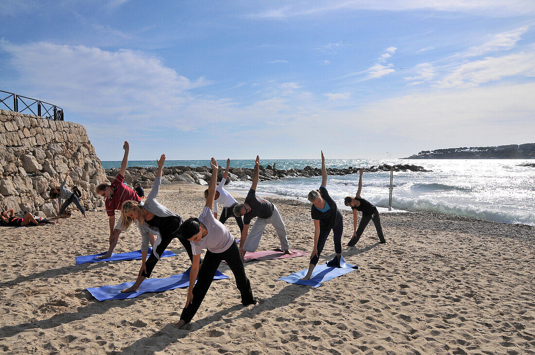 People doing yoga on the beach Plage de la Gravette, Antibes, Cote d'Azur, South France, Europe