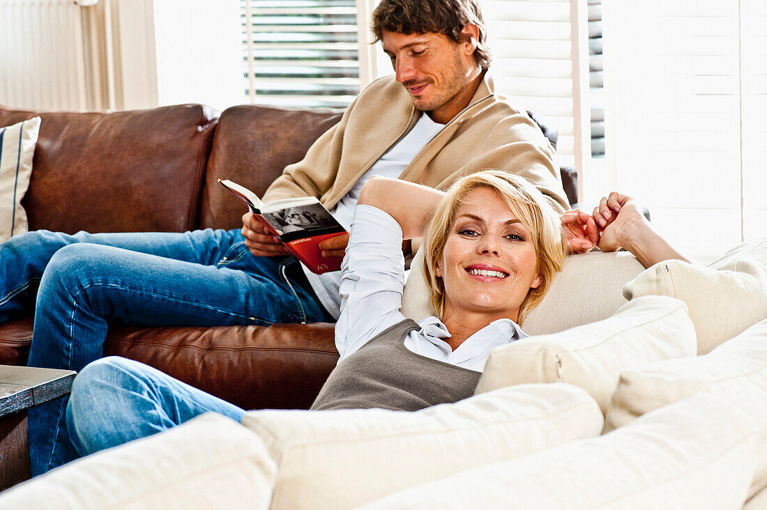 Young couple relaxing on a sofa, Hamburg, Germany