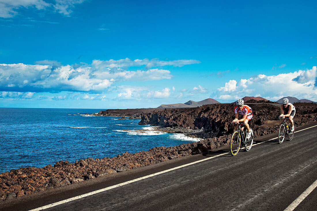 Cyclists at cliff coast, Los Hervideros, Lanzarote, Canary Islands, Spain, Europe