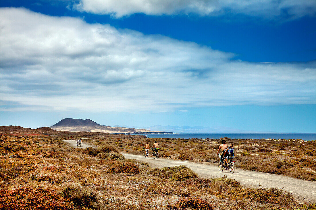 Radfahrer auf einer Küstenstrasse, Insel La Graciosa, Lanzarote, Kanarische Inseln, Spanien, Europa
