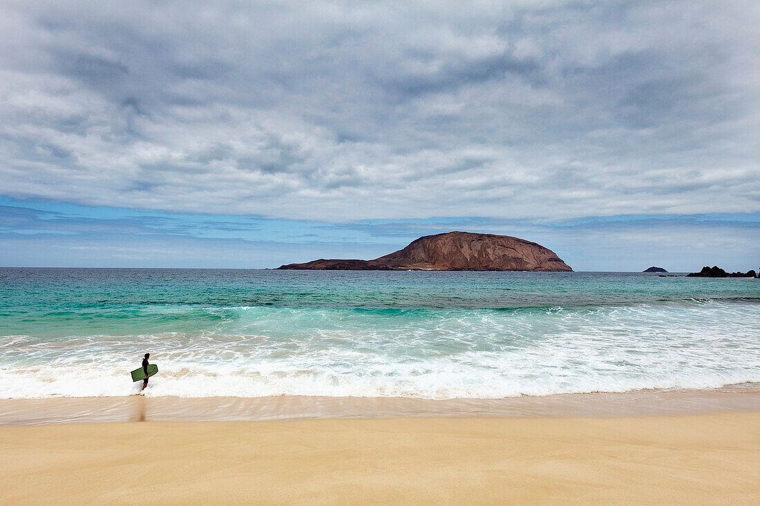 Surfer on the beach, Playa de las Conchas, Island La Graciosa, Lanzarote, Canary Islands, Spain, Europe