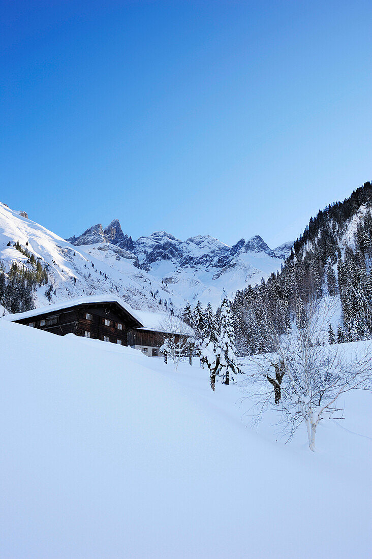 Snow-covered alpine hut of Einoedsbach with summits of Trettachspitze and Maedelegabel in background, Einoedsbach, Oberstdorf, Allgaeu range, Allgaeu, Swabia, Bavaria, Germany