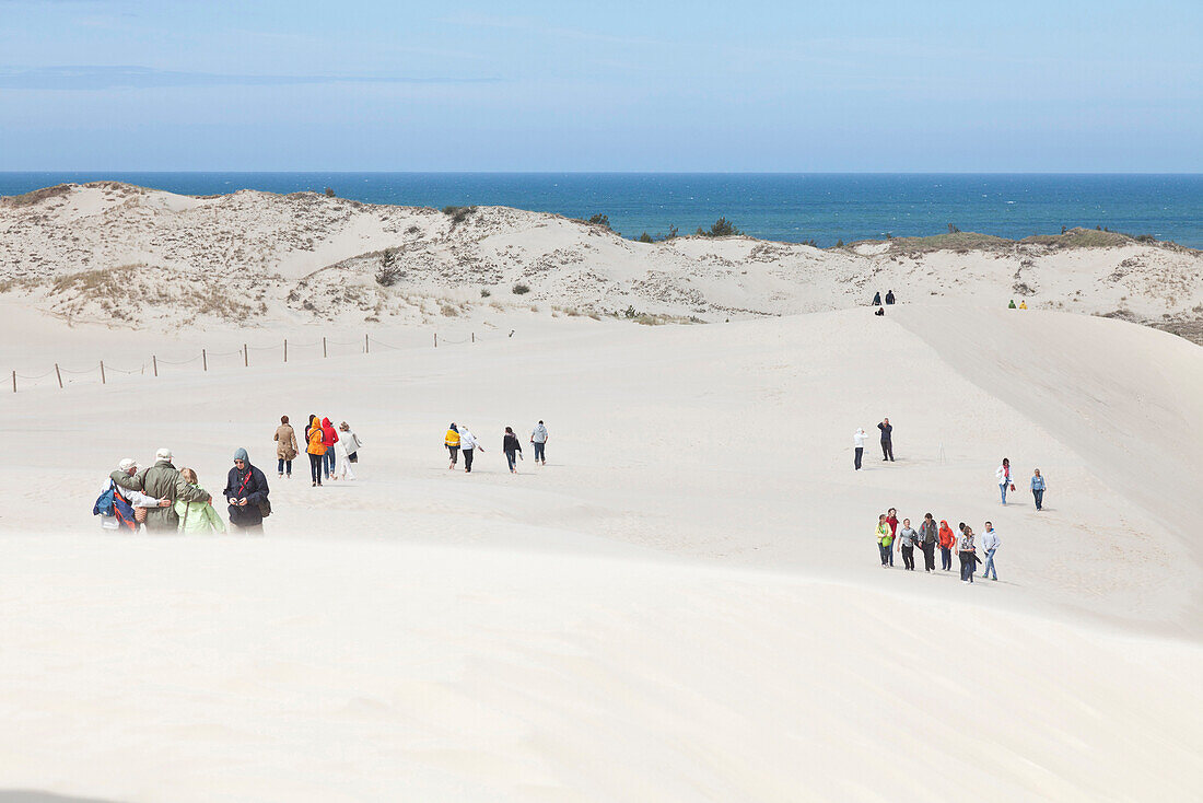 Tourists walking in the dunes, view of the sand grass, UNESCO World Biosphere Reserve, Slowinski National Park, Polish Baltic Sea coast, Leba, Pomeranian, Poland