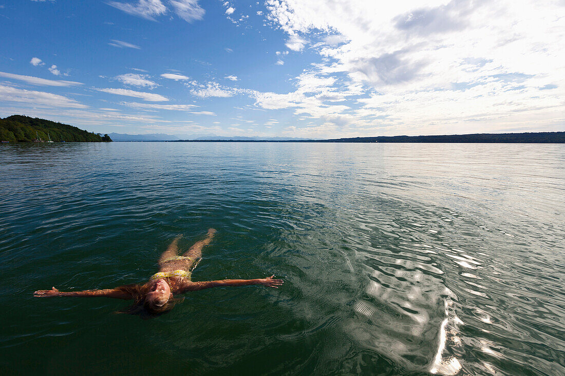 Junge Frau schwimmt in Starnberger See, Oberbayern, Deutschland