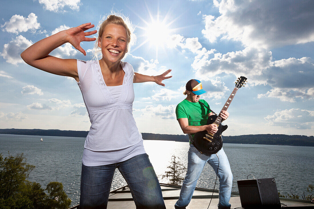 Junge Frau und Gitarrist über dem Starnberger See, Oberbayern, Deutschland