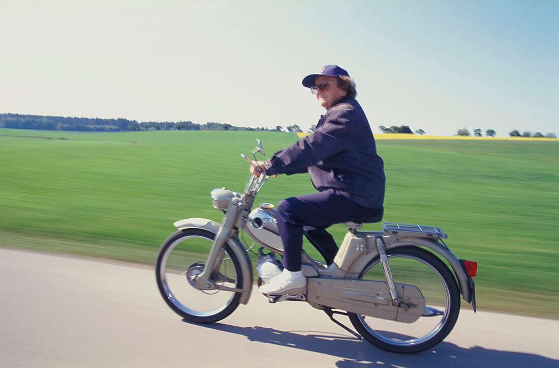 Old woman riding a moped, Upper Bavaria, Germany