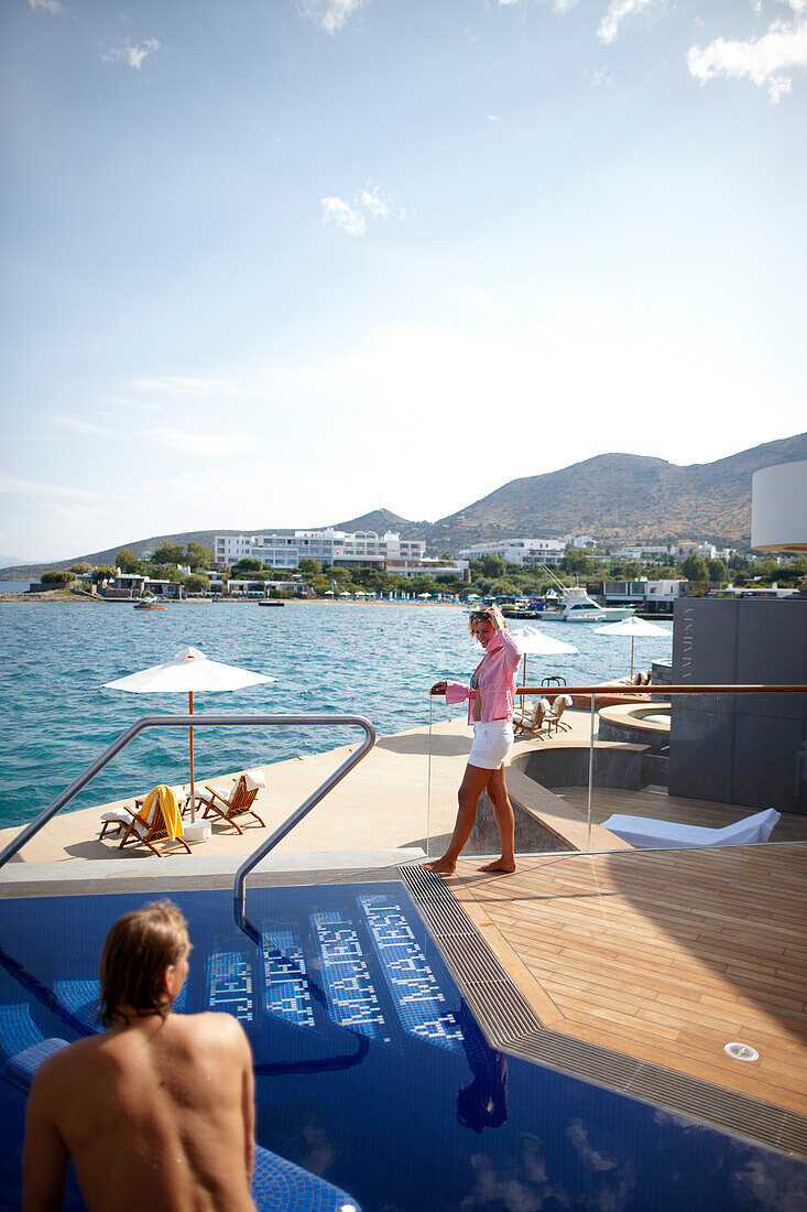 Mann und Frau am Pool und Deck der Yachting Club Villas, Elounda Beach Resort, Elounda, Kreta, Griechenland