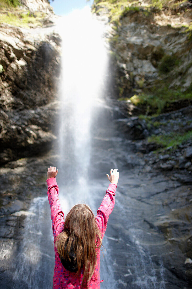 Girl in front of a waterfall, Gossensass, Brenner, South Tyrol, Trentino-Alto Adige/Suedtirol, Italy