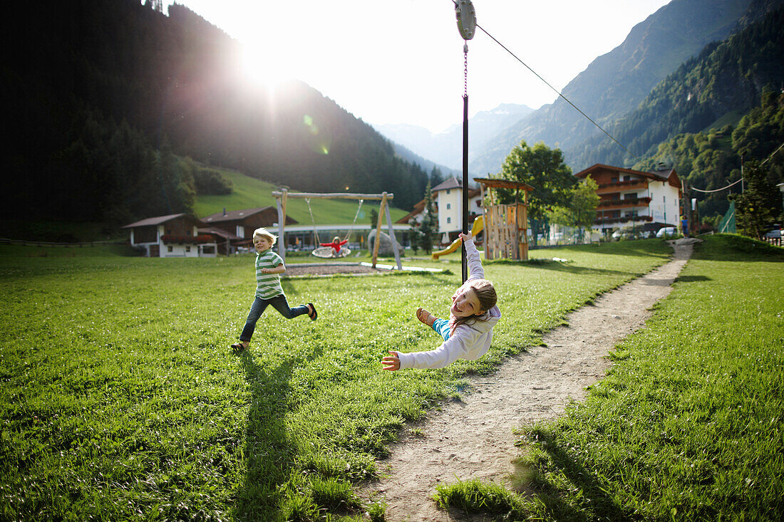 Girl playing on the zip line, outdoor area of a Hotel, Pflersch, Gossensass, South Tyrol, Italy