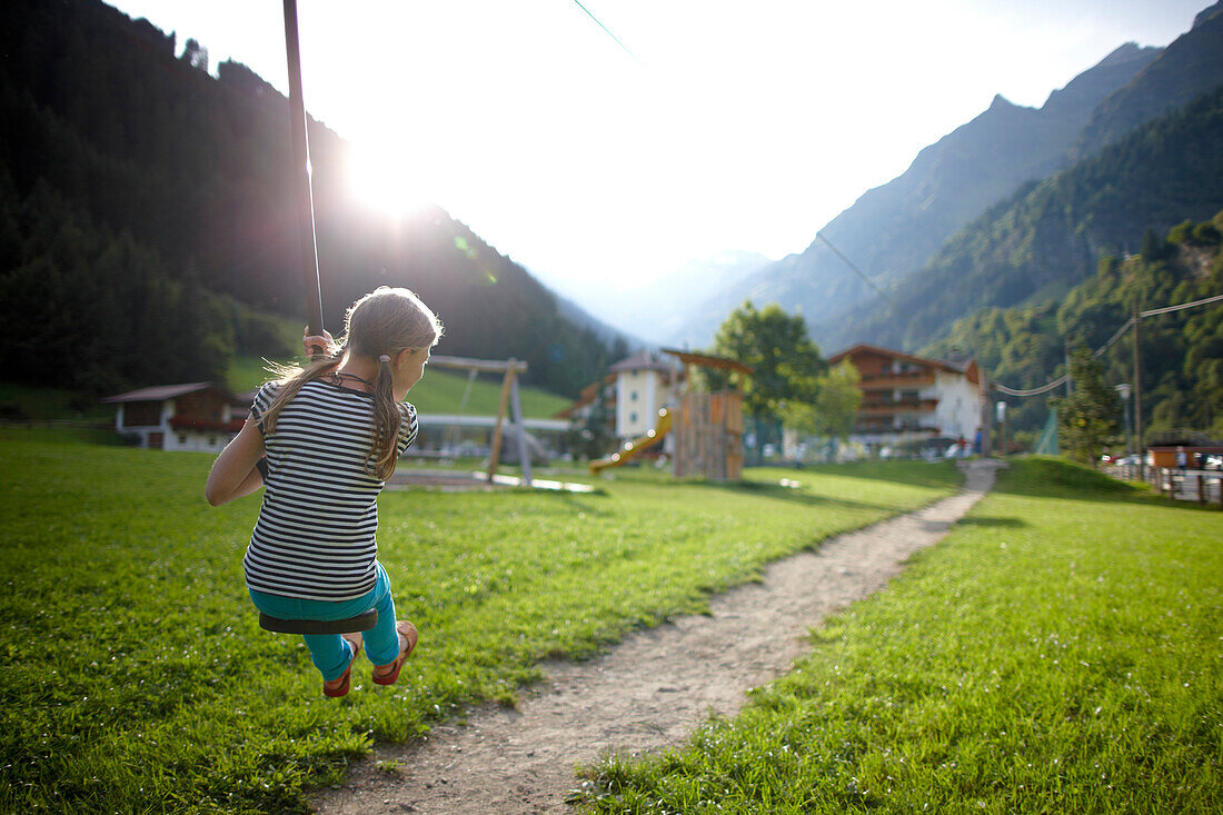 Girl playing on the zip line, outdoor area of Hotel Feuerstein, Pflersch, Gossensass, South Tyrol, Italy
