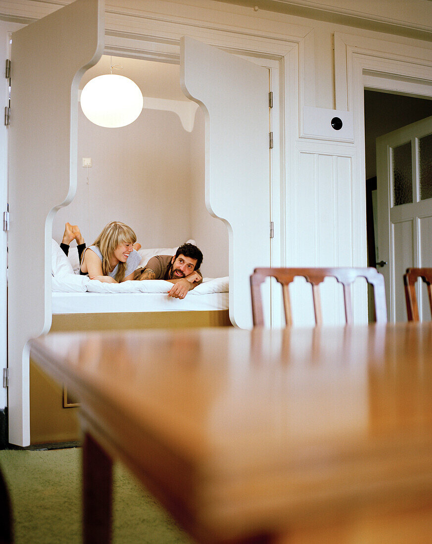 Couple in a cupboard bed of a 4 star room in the Lloyd Hotel, Zeeburg, Amsterdam, Netherlands