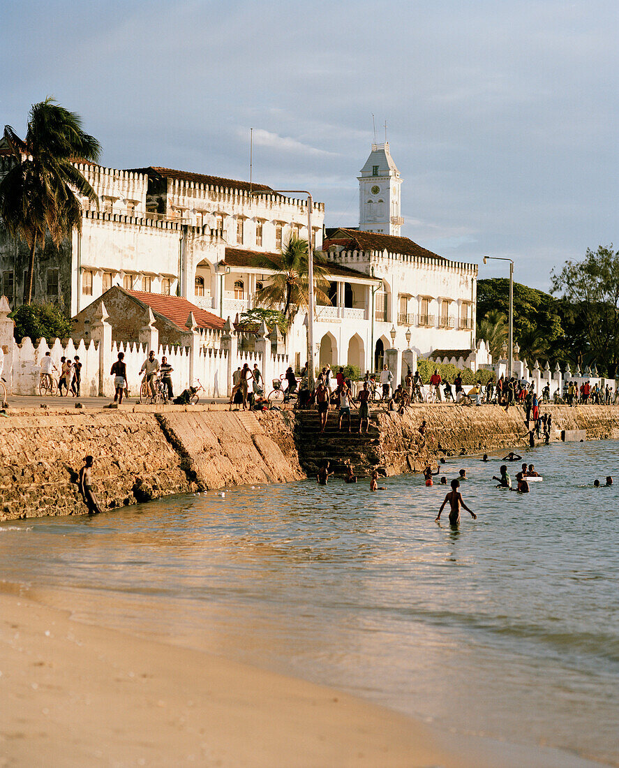 Badende Jungen an Malindi Beach, Mzingani Road, Uferstraße der Stone Town, Hafenbucht, Turm des House of Wonders, Sansibar, Tansania, Ostafrika
