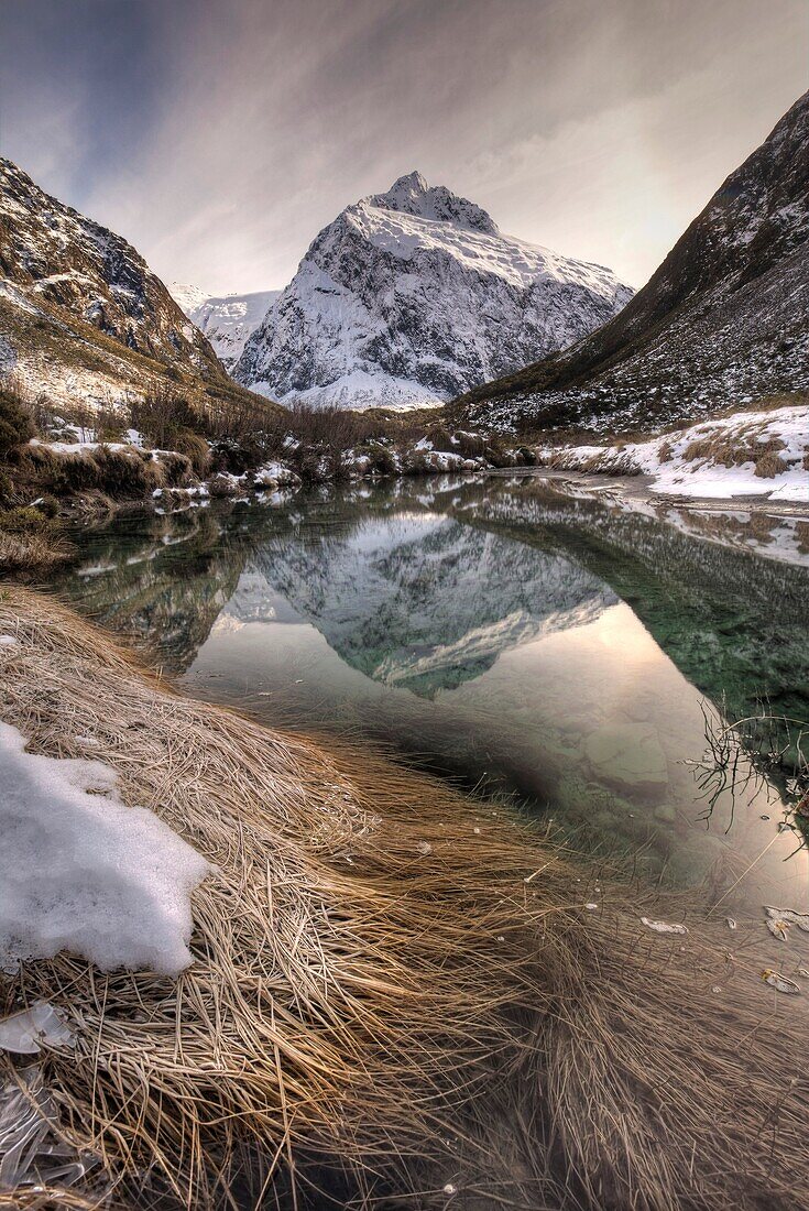 Mt Talbot, winter reflection with ice halo in sky, Hollyford valley, Fiordland National Park, World Heritage site