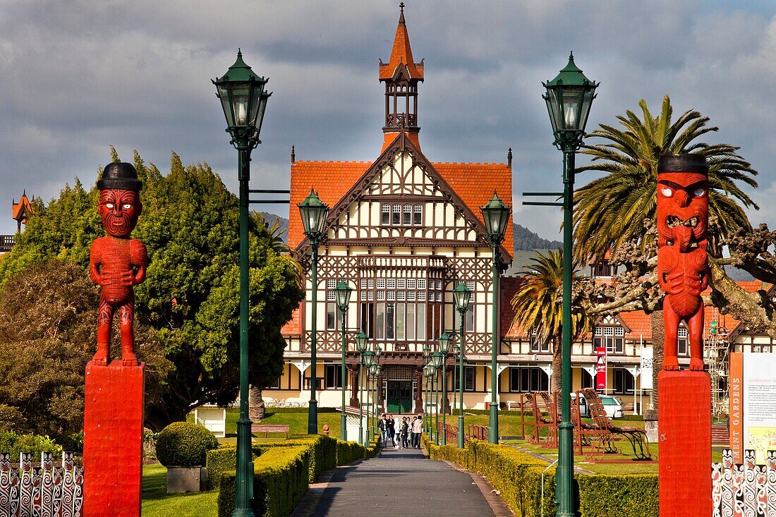 Rotorua Museum entrance pathway lined by lamps and Maori wooden carved figures, Government gardens, Rotorua