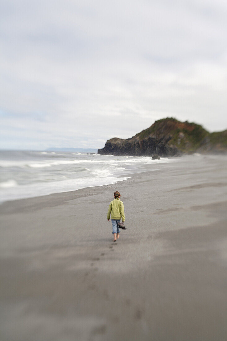 Young Girl Walking Barefoot Along Sandy Beach, Rear View, Redwood National Park, California, USA