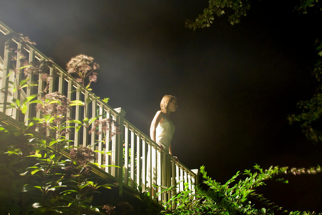 Girl Standing on Balcony at Night