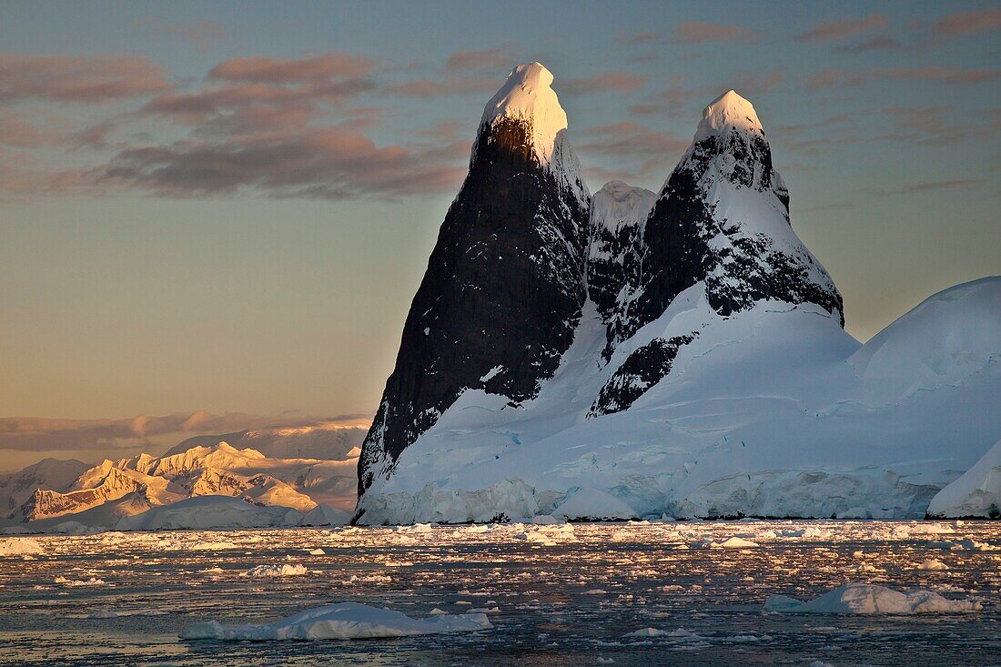Last rays of evening light catch tips of Cape Renard peaks at entrance to Lemaire Channel, Antarctic Peninsula