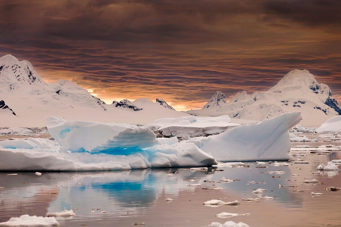 Storm clouds gather at sunset over peaks around Wiencke Island, Neumeyer Channel, Antarctic Peninsula