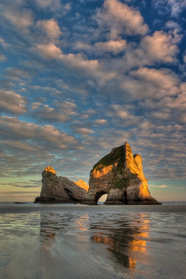 Archway Islands, sunrise lights up high clouds, Wharariki beach, near Collingwood, Golden bay