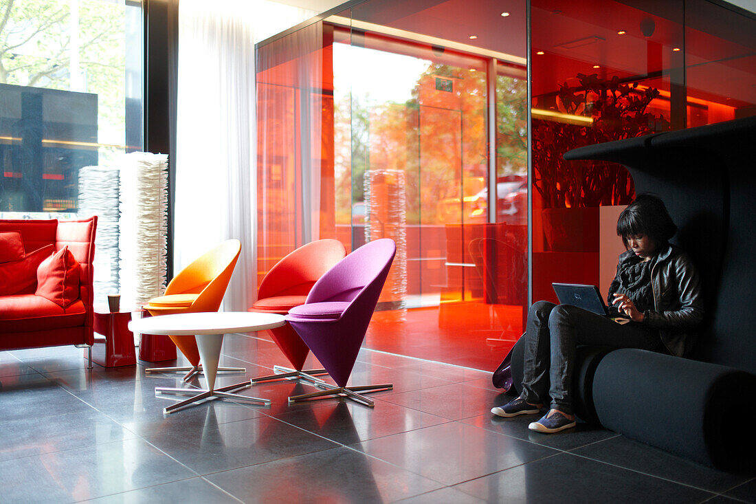 Guest in the Lobby with designer furniture, Citizen M Hotel, Amsterdam, Netherlands