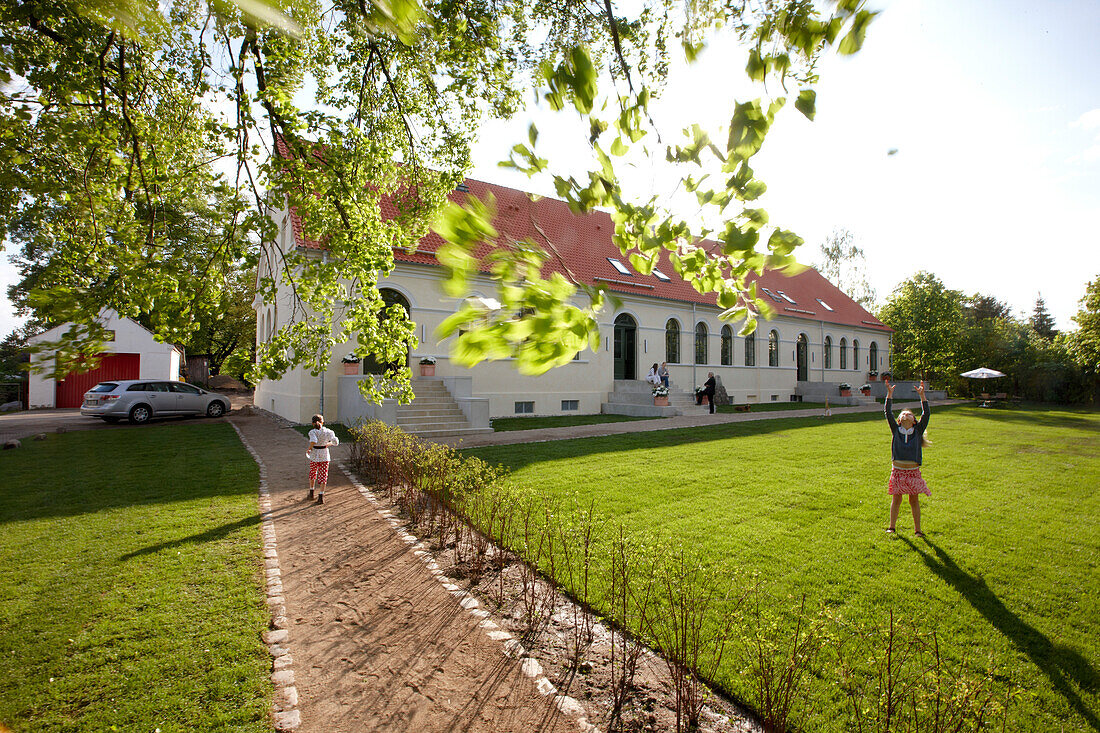 Children playing on meadow near a hotel, lake Fincken, Fincken, Mecklenburg-Western Pomerania, Germany