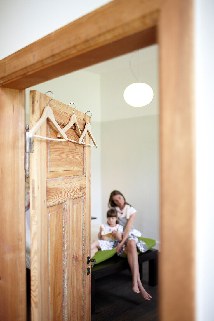 Mother and daughter sitting on a hotel bed, Fincken, Mecklenburg-Western Pomerania, Germany