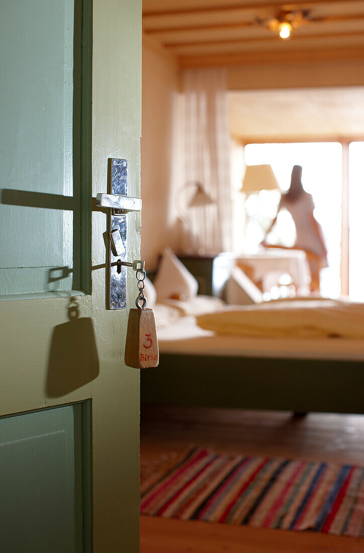 Woman in a hotel room, door with key in foreground, Am Hochpillberg, Schwaz, Tyrol, Austria