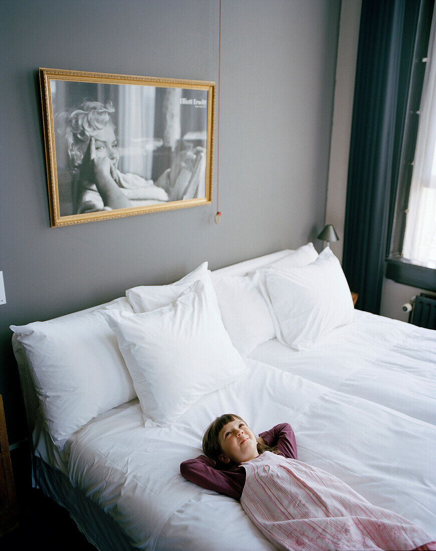 Mädchen liegt auf einem Hotelbett, Zimmer 112, Hotel New York, Kop van Zuid, Rotterdam, Niederlande