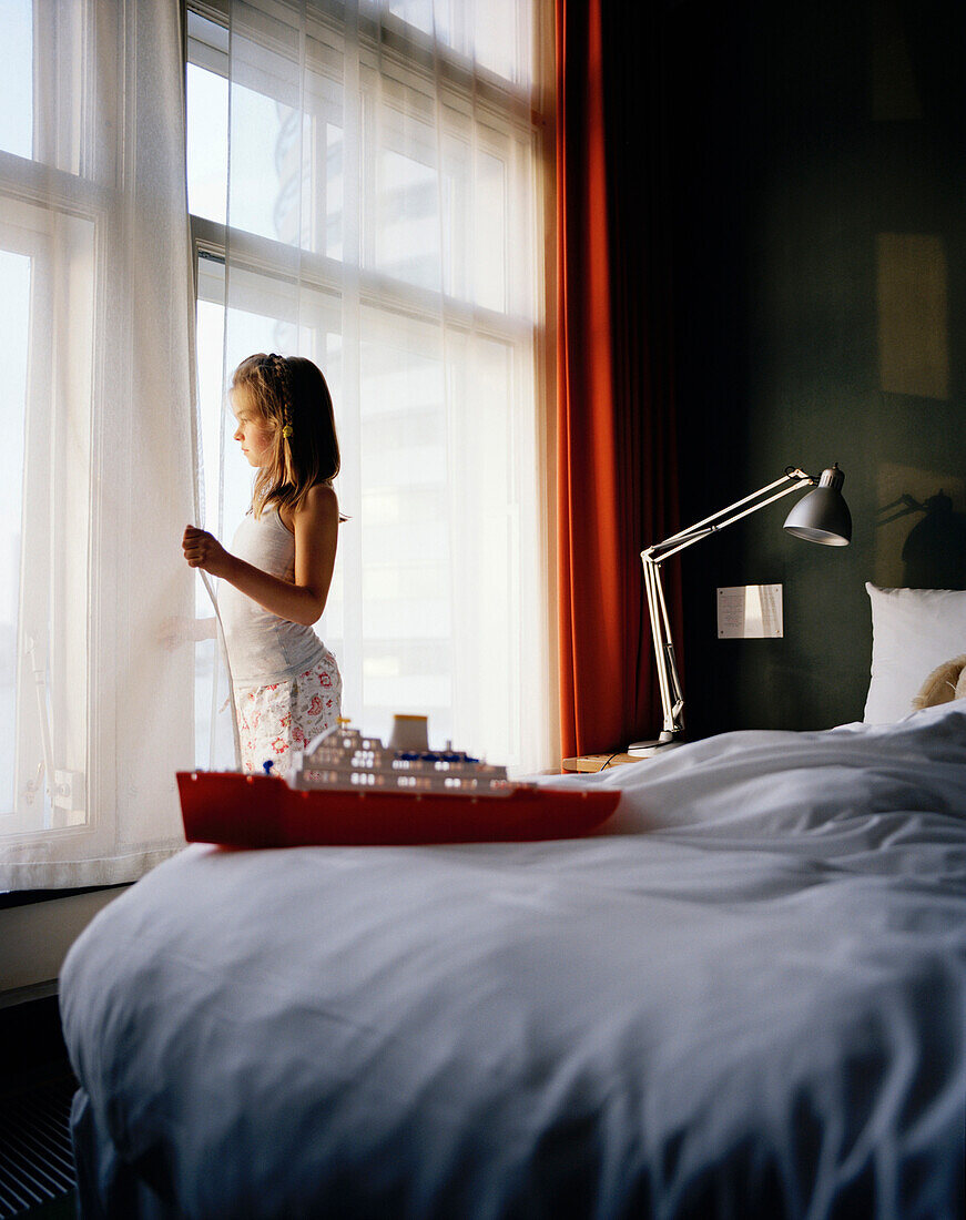 Mädchen sieht aus einem Fenster, Modellschiff im Vordergrund, Hotel New York, Kop van Zuid, Rotterdam, Niederlande