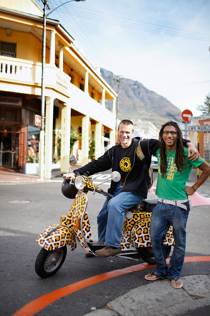 Two men on leopard print scooter cruising through Observatory, Southern Suburbs, Cape Town, South Africa, Africa