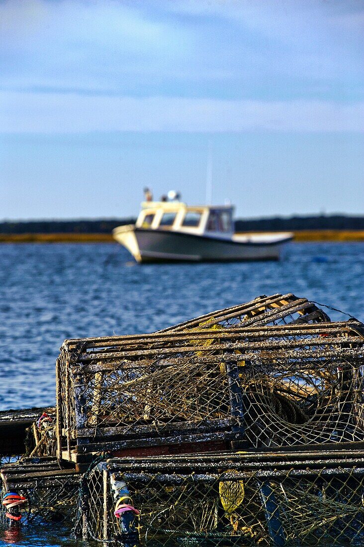 Wooden lobster traps and boat in Nauset Harbor, Orleans, Cape Cod, MA, USA