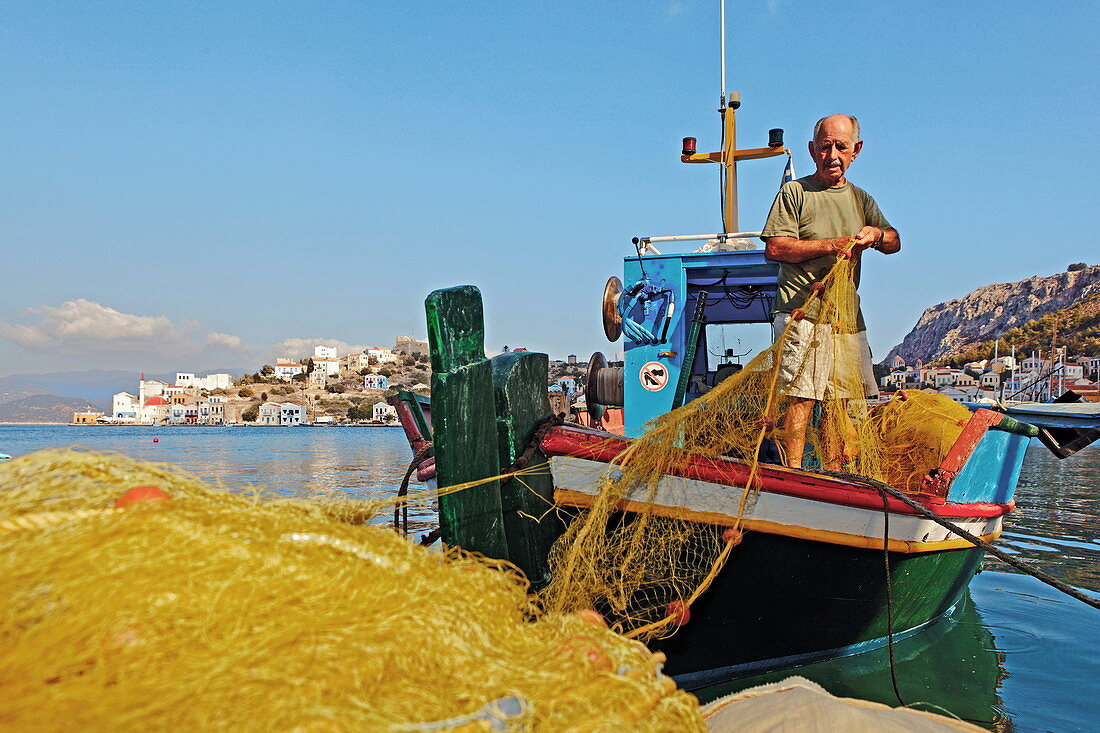 Fisherman on his boat in the port of Kastelorizo Megiste, Dodecanese Islands, Greece, Europe