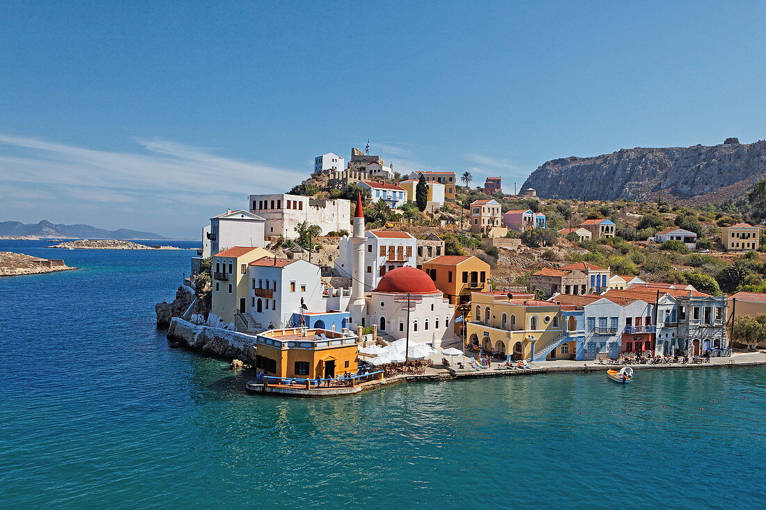 Blick auf Häuser an der Küste im Sonnenlicht, Kastelorizo Megisti, Dodekanes, Griechenland, Europa