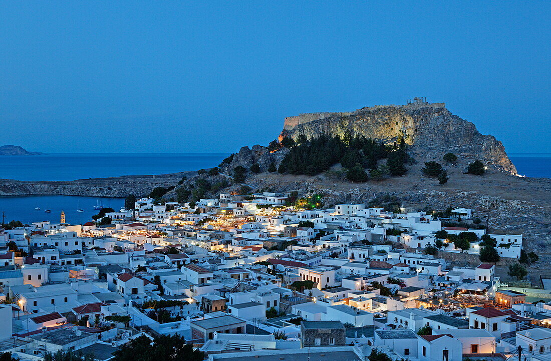 View over the roofs and onto the acropolis in the evening, Lindos, Rhodes, Dodecanese Islands, Greece, Europe