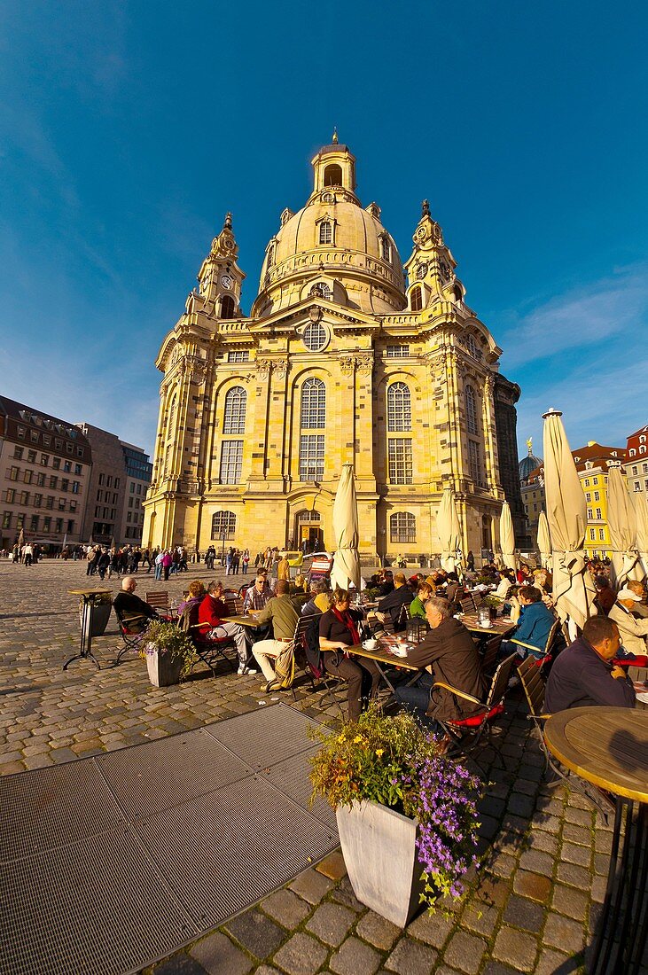 People at sidewalk cafes in the Neumarkt area with the Frauenkiche church in background, Dresden, Saxony, Germany
