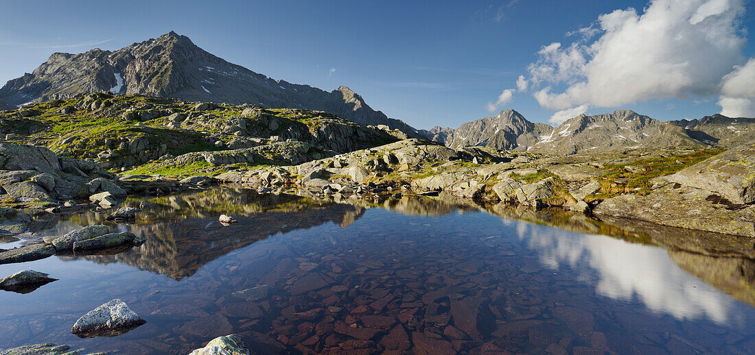 Reflection of the Cima Giner mountain in a mountain lake, Lago Nero, Brenta Adamello Nature Reserve, Trentino, Italy