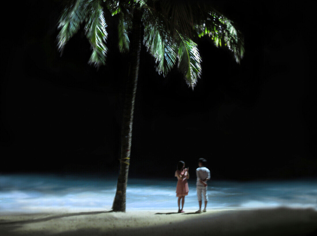 Ein junges Paar am Strand in Boracay in der Nacht, Boracay, Insel Panay, Visayas, Philippinen