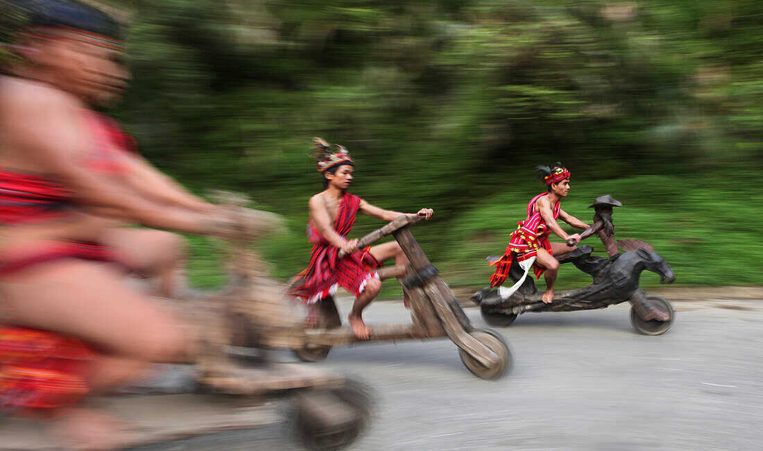 Ifugao men speeding on wooden scooters, Banaue, Ifugao, Luzon Island, Philippines