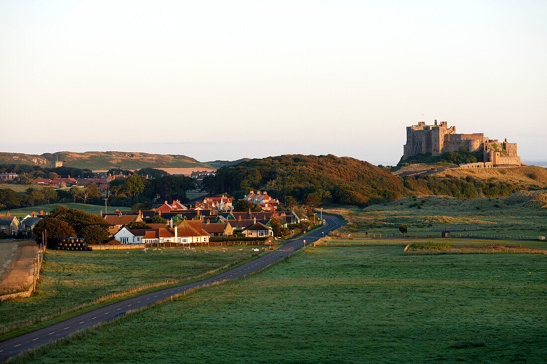 Bamburgh village and Bamburgh Castle in the early morning light, Bamburgh, Northumberland, England, Great Britain, Europe