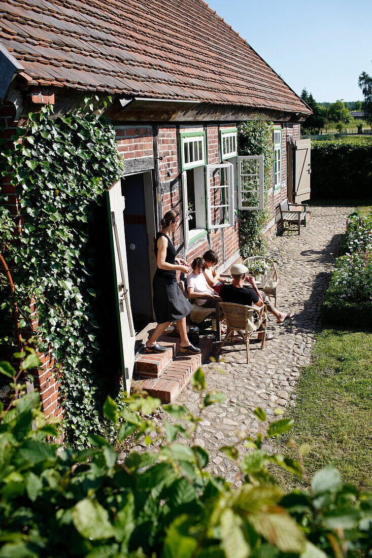 Familie im Garten, Haus Strauss, Bauernkate in Klein Thurow, Roggendorf, Mecklenburg-Vorpommern, Deutschland