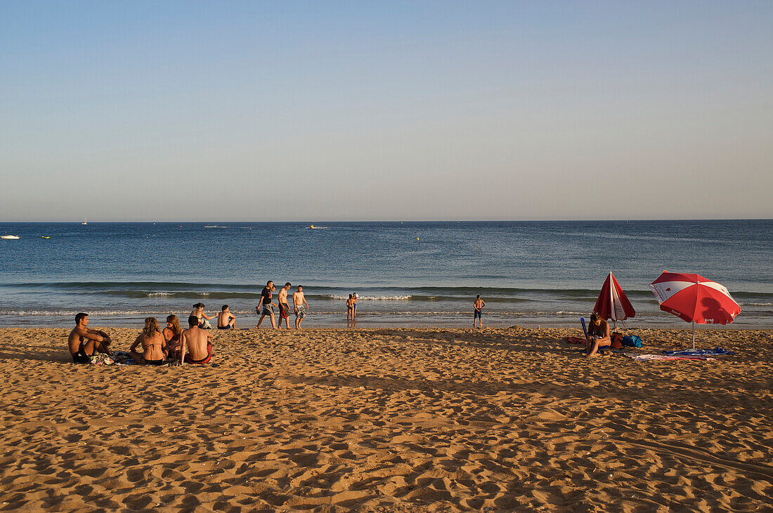 Menschen am Strand in der Abendsonne, Albufeira, Algarve, Portugal, Europa