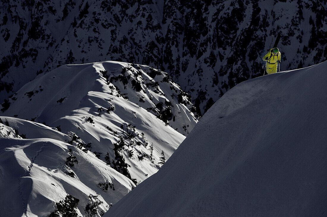 Junger Skifahrer steigt einen Berg hinauf durch Tiefschnee, Iseler, Bayern, Deutschland, Europa