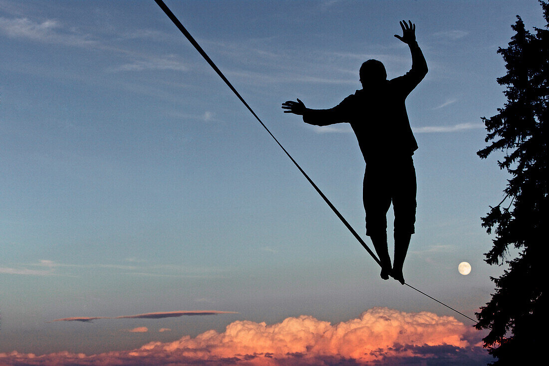 Young man balancing on a longline at sunset, Auerberg, Bavaria, Germany, Europe