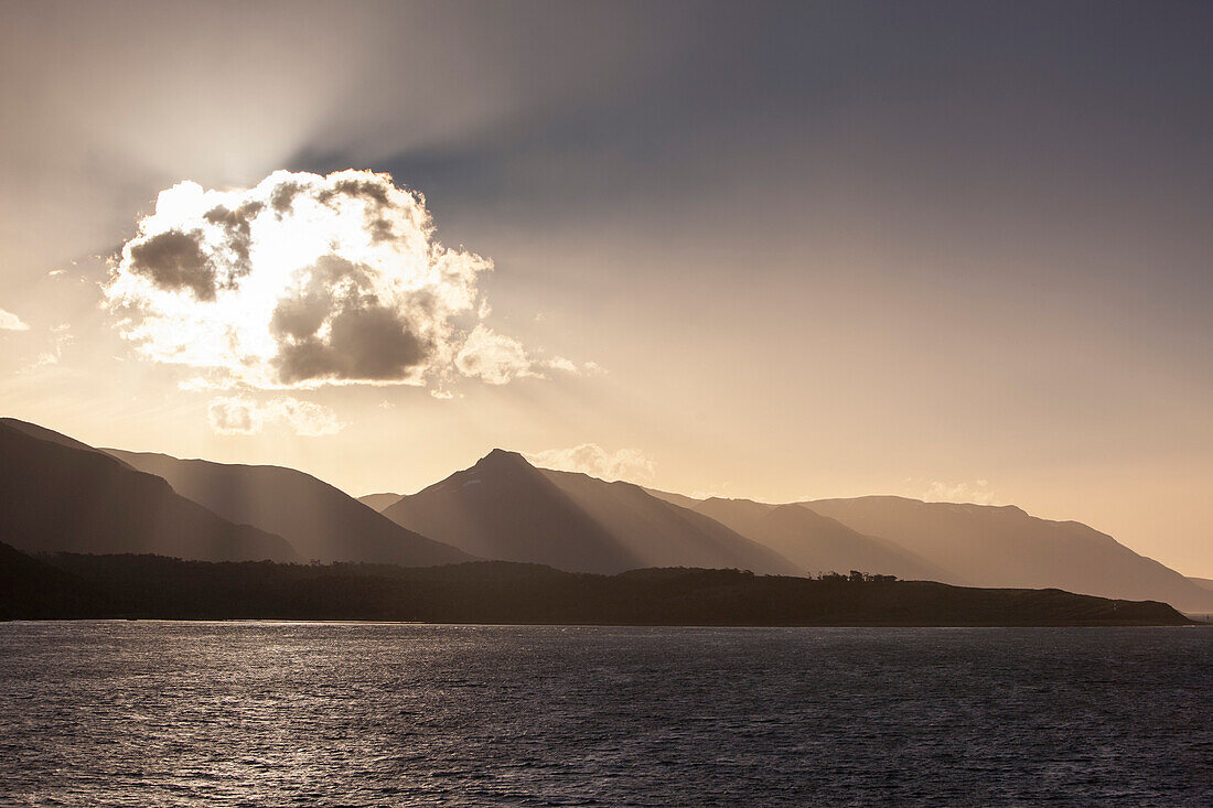 Backlit cloud and Beagle Channel coastline at sunset seen from cruise ship MS Deutschland (Reederei Peter Deilmann), near Puerto Williams, Magallanes y de la Antartica Chilena, Patagonia, Chile, South America