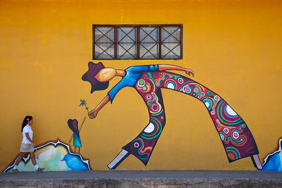 School girl walks in front of mural, Puntarenas, Costa Rica, Central America