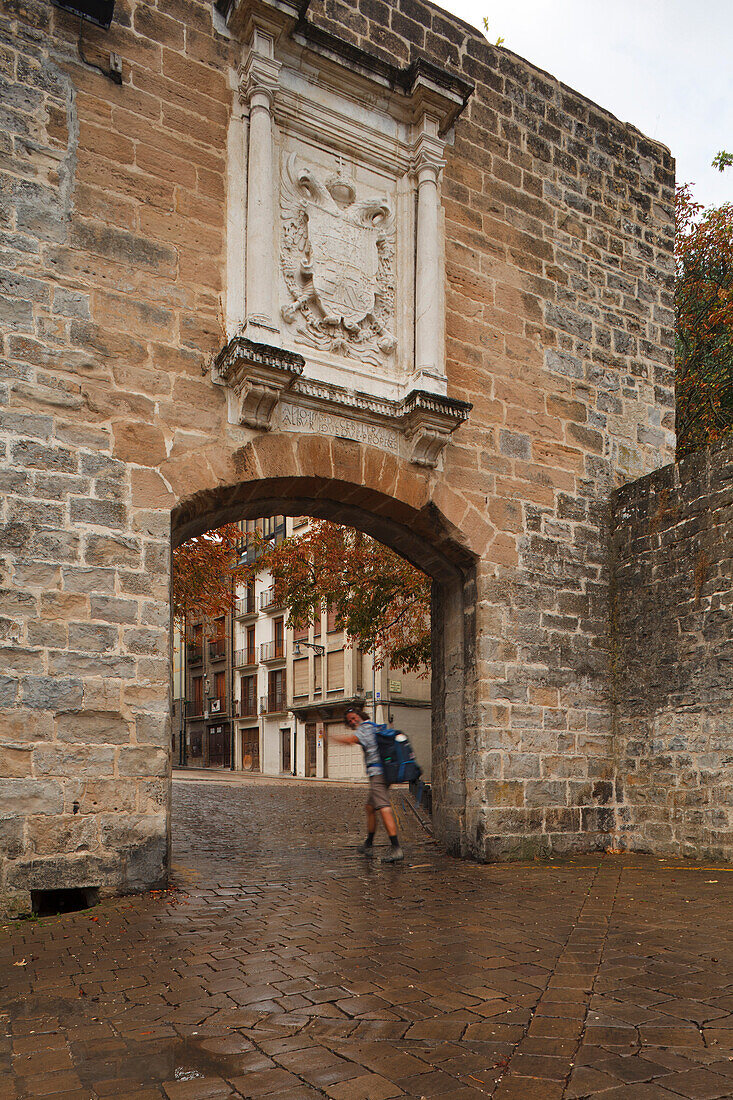 Pilgrim in front of Portal a Francia, town gate at the old town, Pamplona, Camino Frances, Way of St. James, Camino de Santiago, pilgrims way, UNESCO World Heritage, European Cultural Route, province of Navarra, Northern Spain, Spain, Europe